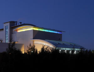 Photo of a Veolia building lit up against a night sky.